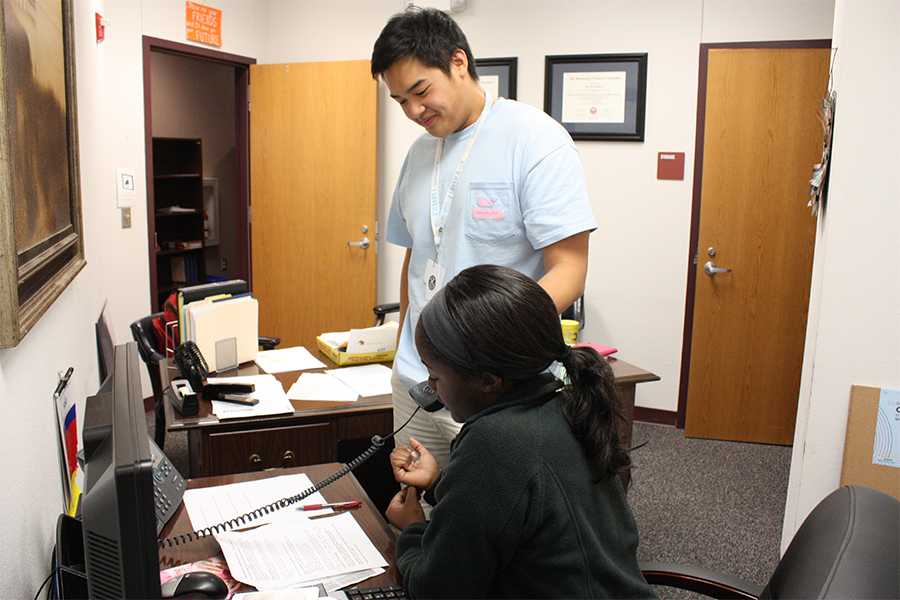 Andrew Loh holds the phone while Niyyah Barber reads an announcement. 