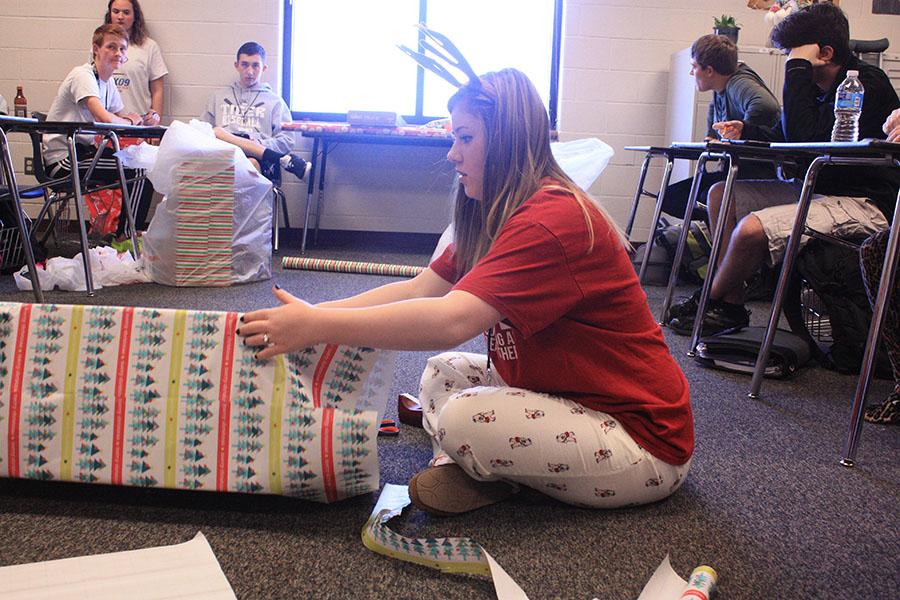 Junior Tori Crawford wraps a present for Adopt-a-Child on Pajama Day. 