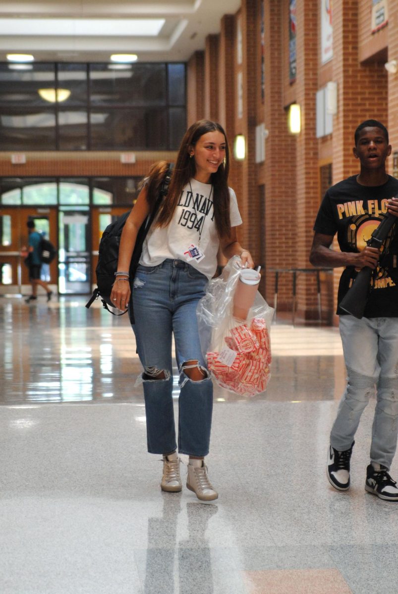 Senior class President Catie Hallmon carrying bags of popcorn. 