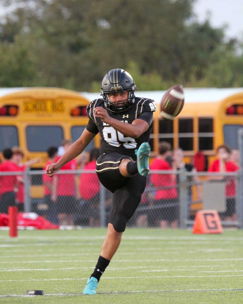 Senior Mauro Manzano kicking a football.