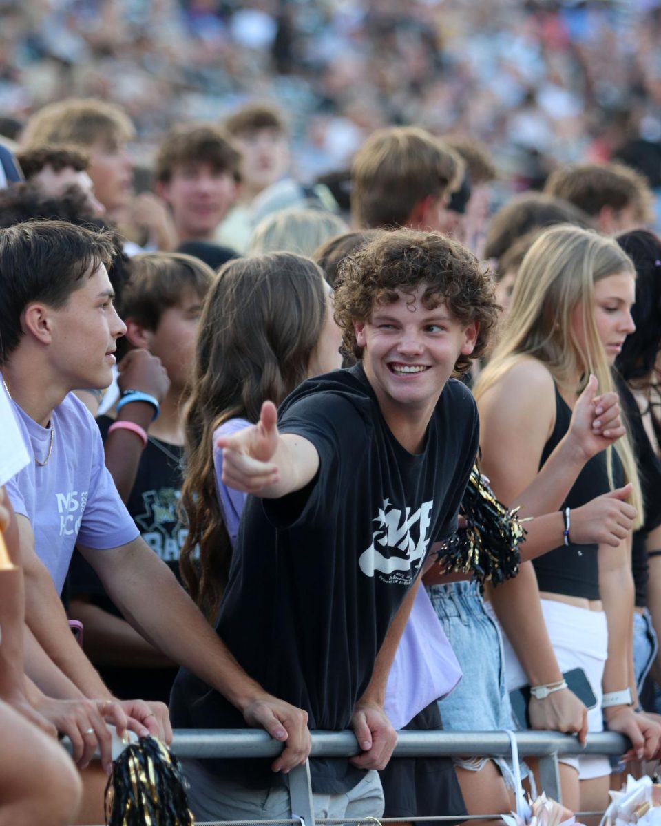 Senior Caden Cone gesturing to a friend during a football game. 