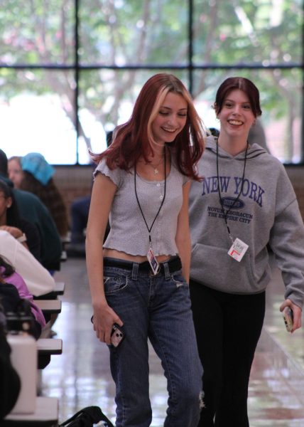 Two students walking through the lunch room.